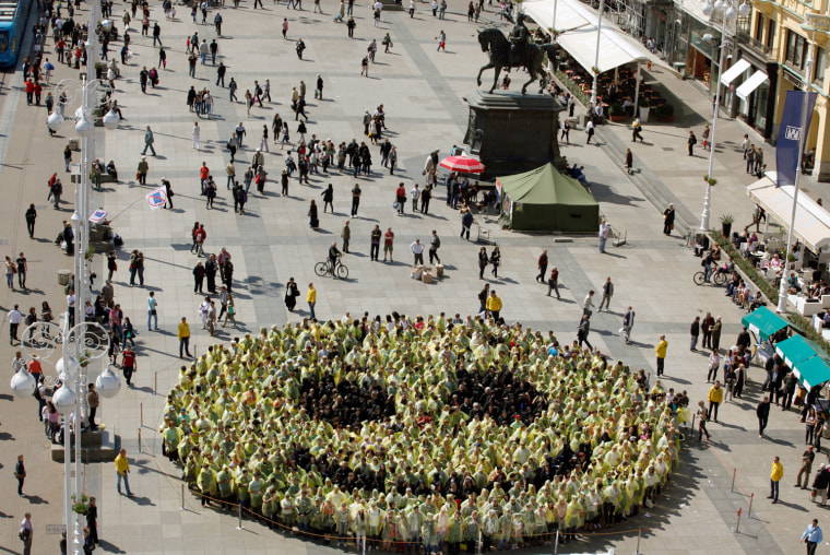 Image: People stand together as they create the biggest human smiley in the world on the Zagreb main square
